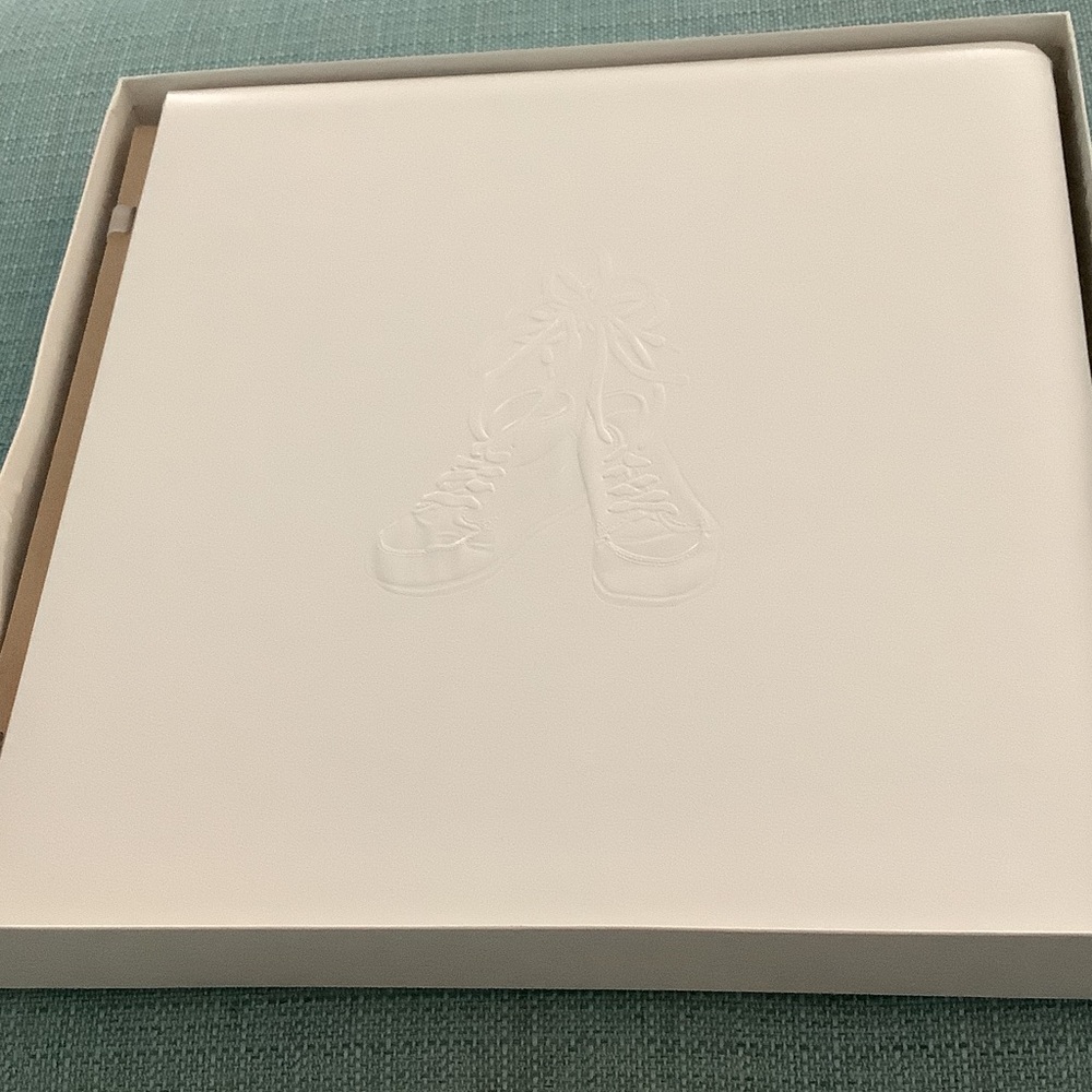 Creative Memories white baby album with embossed baby shoes on front.